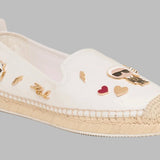 White flat moccasin-styled shoe with decorative elements side 2