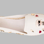 White flat moccasin-styled shoe with decorative elements top