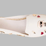 White flat moccasin-styled shoe with decorative elements top