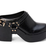 A black leather platform clog shoe with a chunky block heel, a decorative strap across the instep featuring gold-tone studs and a buckle, and a rounded toe, shown against a plain white background.