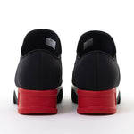 Black slip-on shoe with a red heel and black & white sole heel view