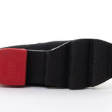 Black slip-on shoe with a red heel and black & white sole sole view
