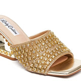 Gold embellished high-heeled shoe front view