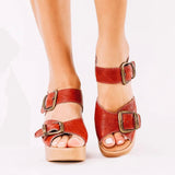 Red wedge sandal with honey sole and brass buckle closure front view