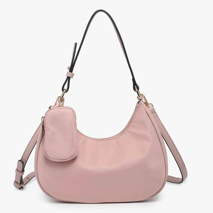 Pink handbag with a shoulder strap and hand strap and small accessory bag close-up