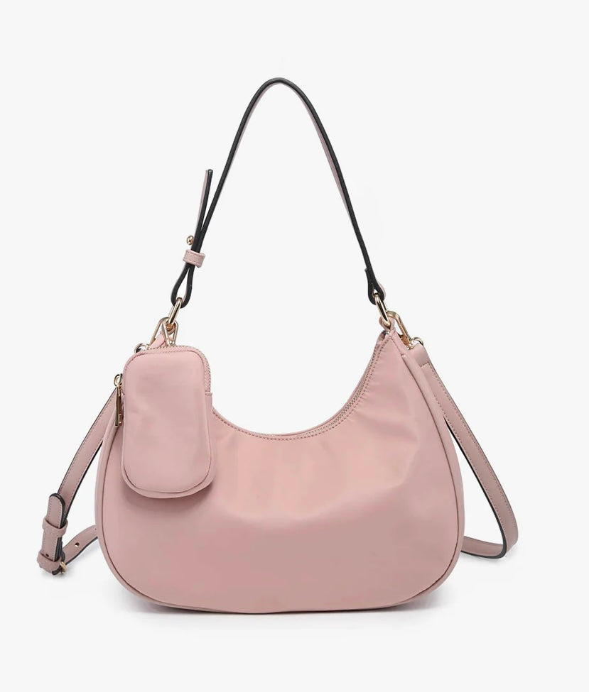 Pink handbag with a shoulder strap and hand strap and small accessory bag close-up