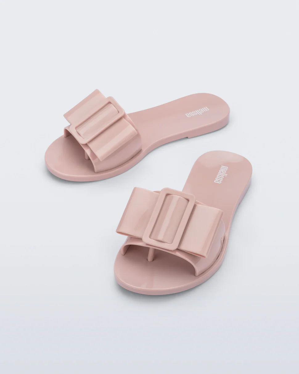 Light pink flat sandal with bow embellishment top view
