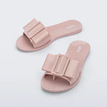 Light pink flat sandal with bow embellishment top view