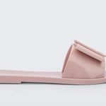 Light pink flat sandal with bow embellishment close-up