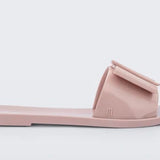 Light pink flat sandal with bow embellishment close-up