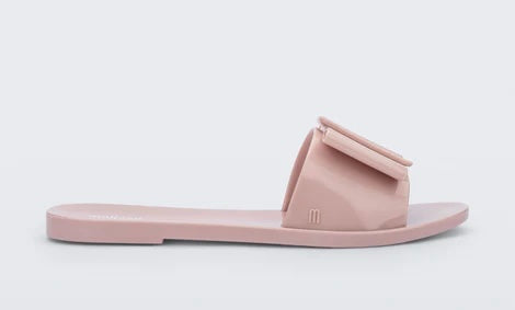 Light pink flat sandal with bow embellishment close-up