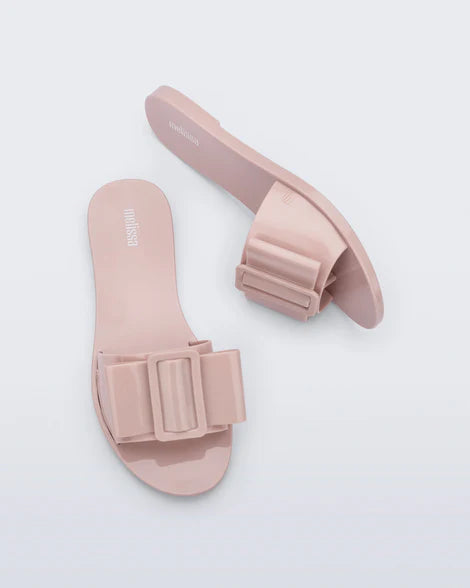 Light pink flat sandal with bow embellishment top & side view