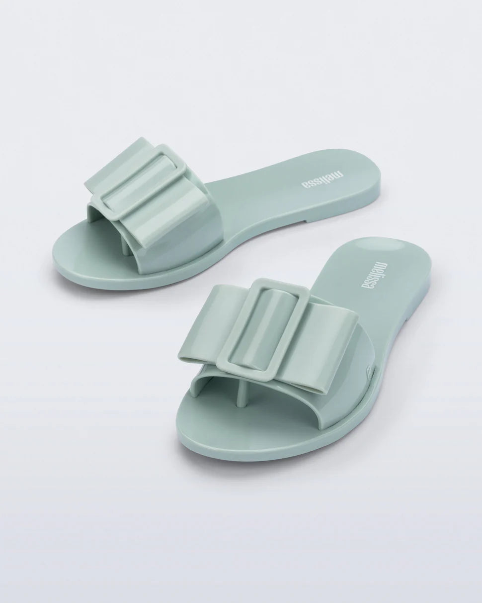 Light turquoise flat sandal with bow embellishment top view