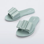 Light turquoise flat sandal with bow embellishment top view