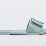 Light turquoise flat sandal with bow embellishment close-up