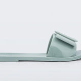 Light turquoise flat sandal with bow embellishment close-up
