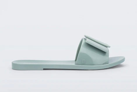Light turquoise flat sandal with bow embellishment close-up