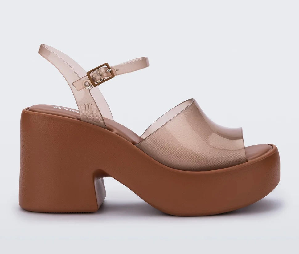 Brown platform sandal with translucent straps and buckle closure close-up