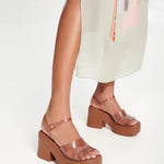 Brown platform sandal with translucent straps and buckle closure model