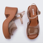 Brown platform sandal with translucent straps and buckle closure top and side view