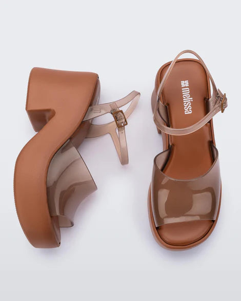 Brown platform sandal with translucent straps and buckle closure top and side view