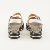 White sandal with colorful floral decorations and black & white sole heel view