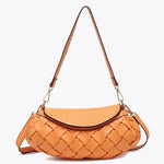 Orange handbag with woven texture and gold accents close-up