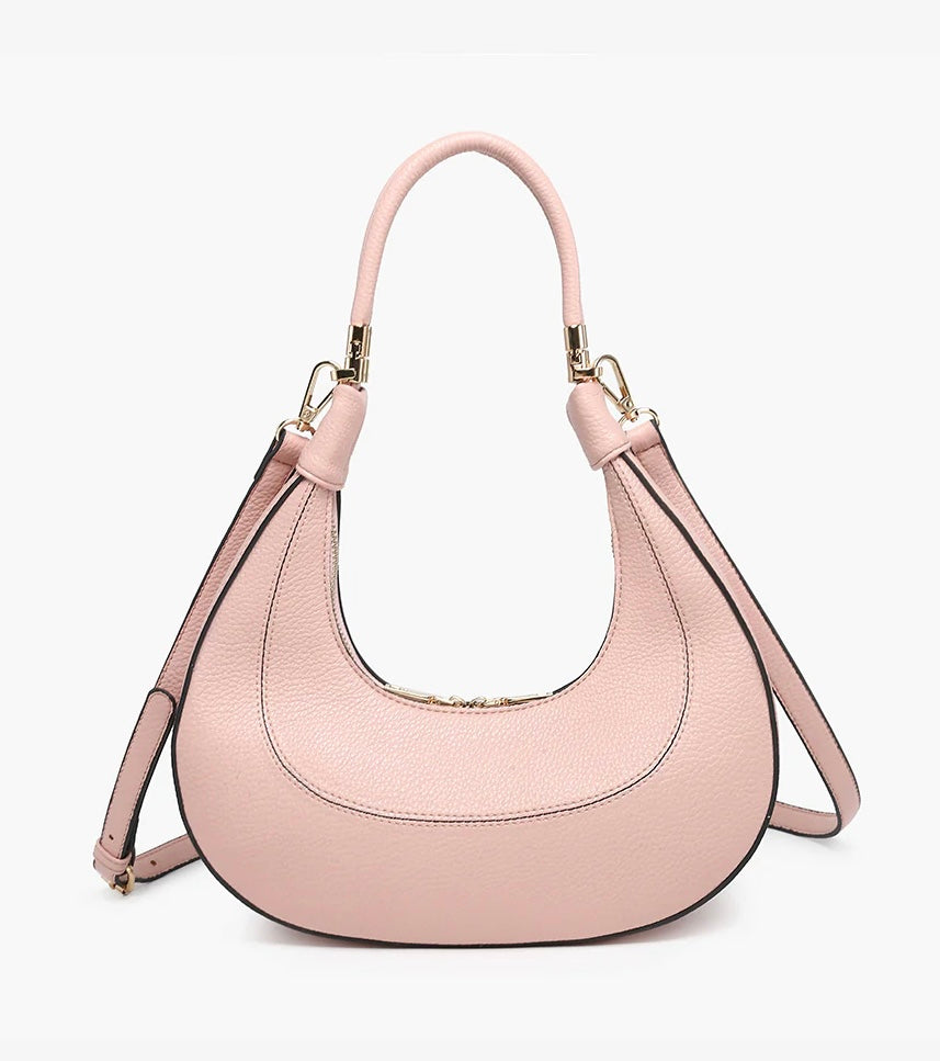 Pink handbag with a hand strap and shoulder strap close-up