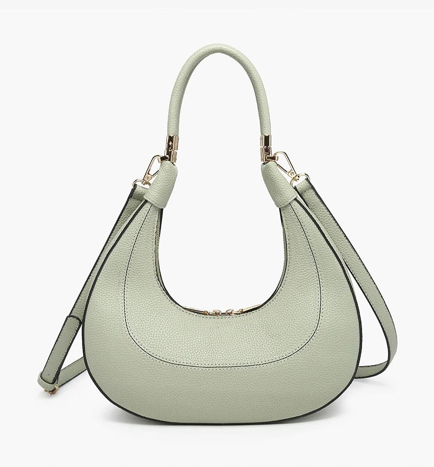Light green handbag with a hand strap and shoulder strap close-up