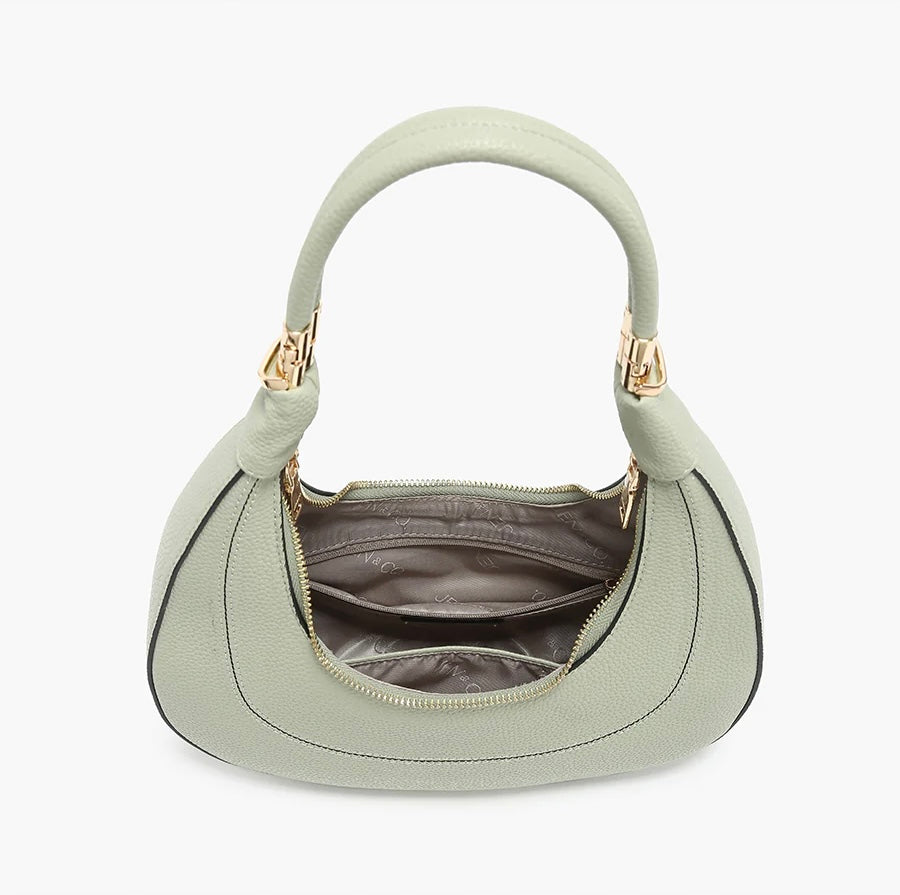 Light green handbag with a hand strap and shoulder strap opening
