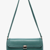 Green handbag with a strap and brass clasp close-up