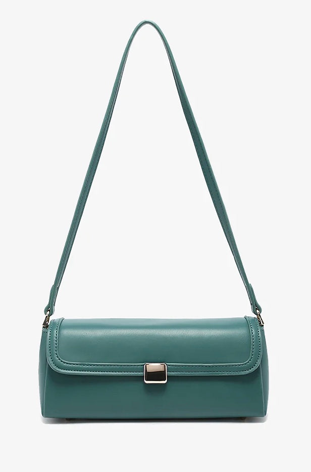 Green handbag with a strap and brass clasp close-up