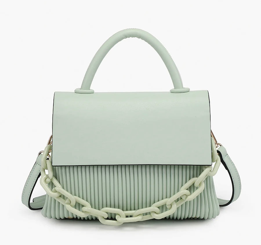 Light green handbag with a chain detail, hand strap and shoulder strap close-up