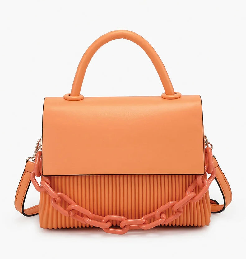 Orange handbag with a chain detail, hand strap and shoulder strap close-up
