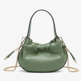 Green handbag with chain detail and hand strap close-up