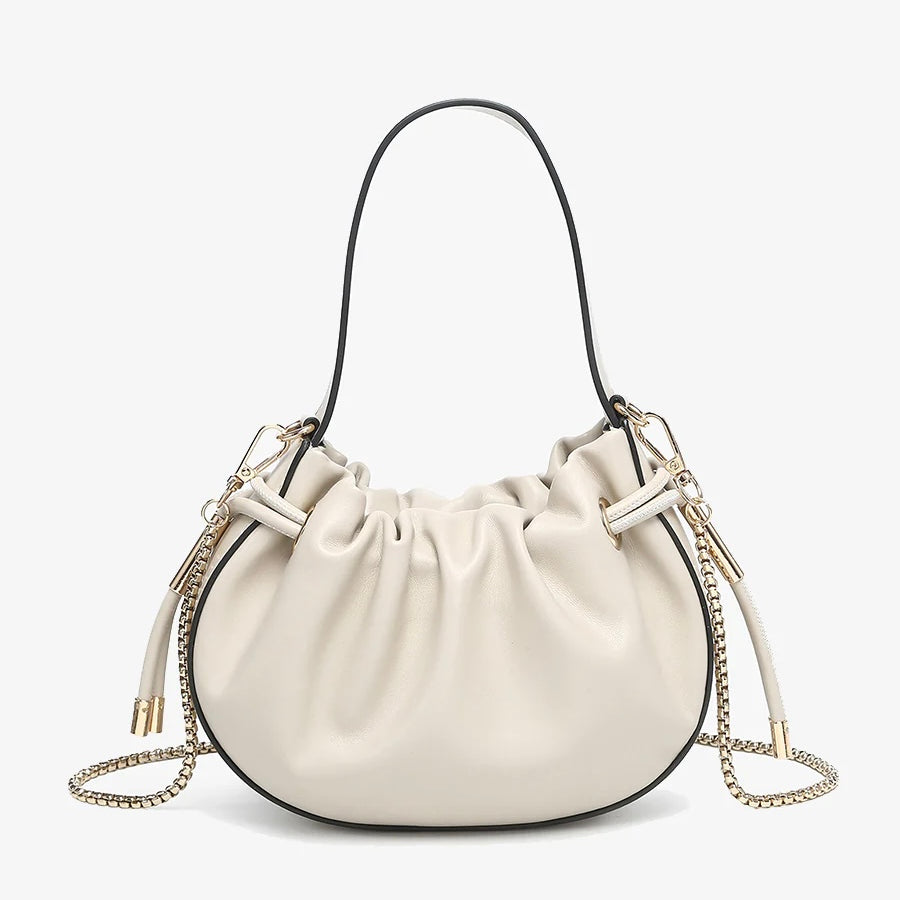 Cream handbag with chain detail and hand strap close-up
