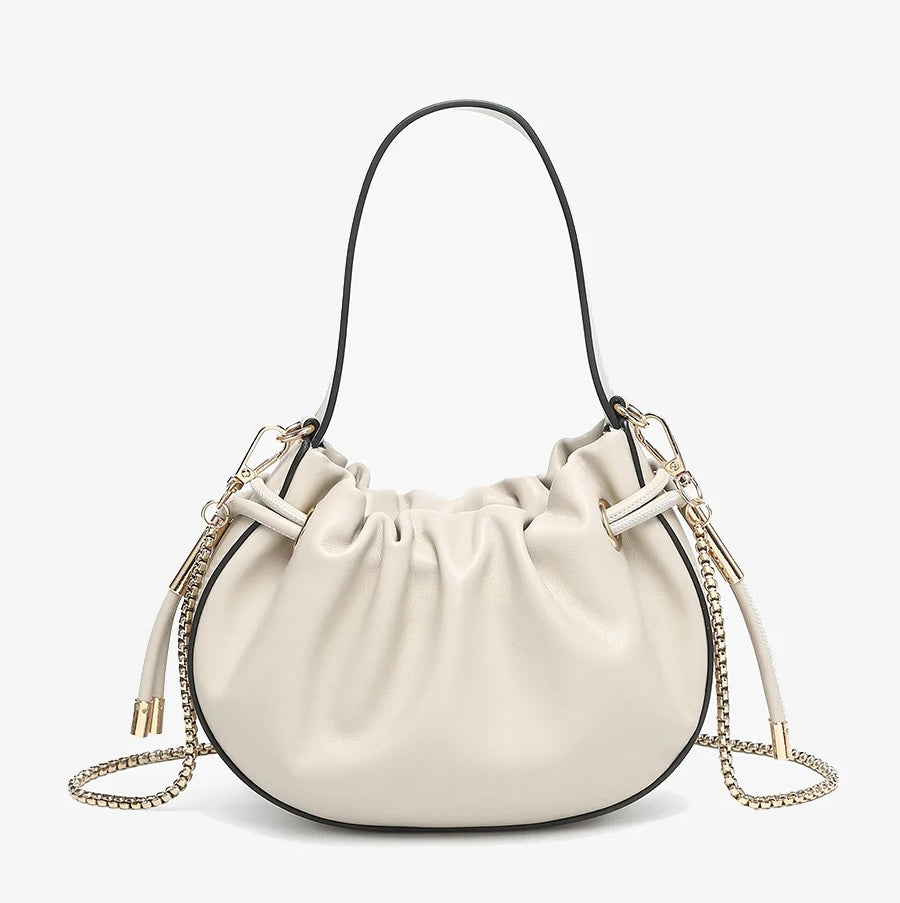 Cream handbag with chain detail and hand strap close-up
