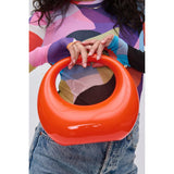 Orange circular acrylic handbag with a gold chain strap model