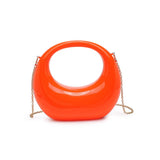 Orange circular acrylic handbag with a gold chain strap