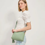 Green textured handbag with a green black and white striped strap model 