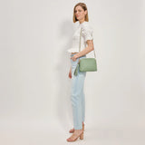 Green textured handbag with a green black and white striped strap model 3