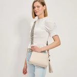White textured handbag with a black and white striped strap model