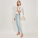 White textured handbag with a black and white striped strap model 3