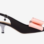Black high-heeled shoe with pink bow close-up