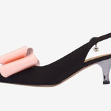Black high-heeled shoe with pink bow side view