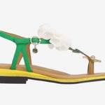 Green sandal with a white flower and yellow heel close-up