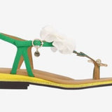 Green sandal with a white flower and yellow heel close-up