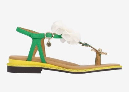 Green sandal with a white flower and yellow heel close-up