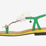 Green sandal with a white flower and yellow heel side view