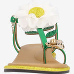Green sandal with a white flower and yellow heel toe box